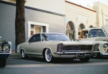 white coupe parked near tree and building