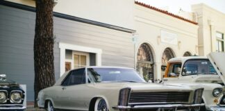 white coupe parked near tree and building