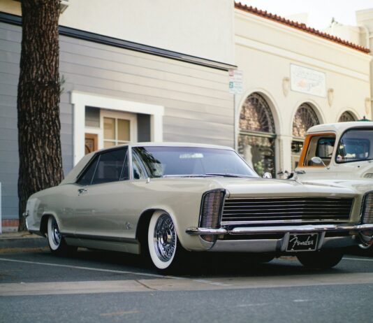 white coupe parked near tree and building